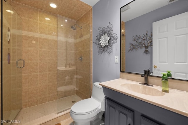 bathroom with vanity, a shower with shower door, and toilet