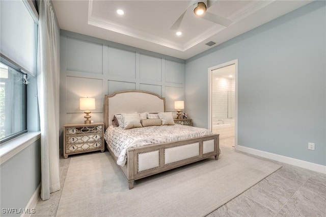 bedroom featuring crown molding, connected bathroom, and a tray ceiling