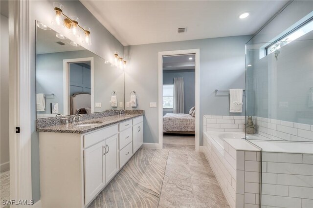 bathroom featuring vanity and tiled tub