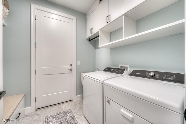 laundry room featuring cabinets and washer and clothes dryer