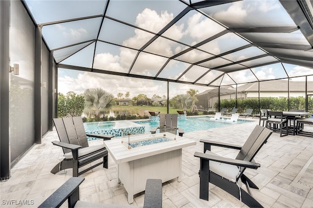 view of patio featuring a swimming pool with hot tub, pool water feature, a fire pit, and a lanai