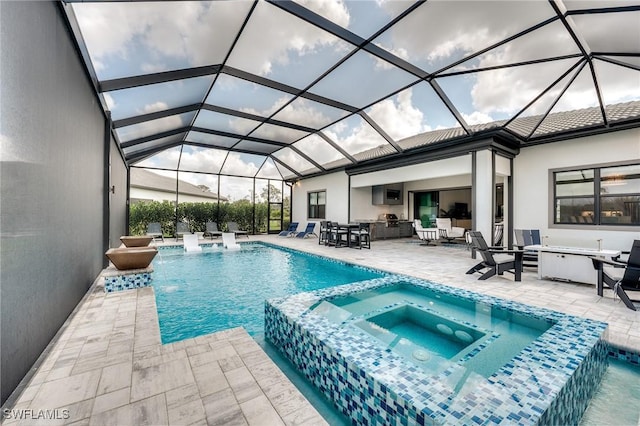 view of pool featuring a patio, pool water feature, glass enclosure, and an in ground hot tub