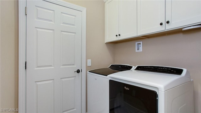 washroom with washing machine and dryer and cabinets