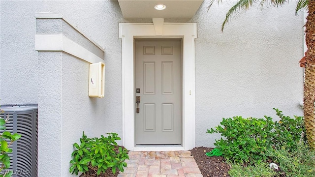 view of exterior entry with central AC unit