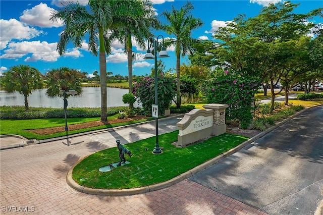 view of home's community featuring a lawn and a water view