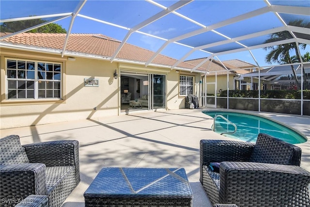 view of pool featuring glass enclosure and a patio area