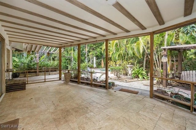 unfurnished sunroom featuring beamed ceiling