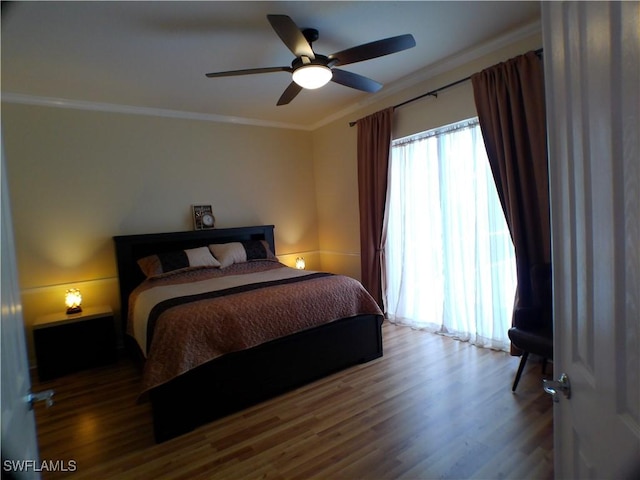 bedroom with ceiling fan, wood-type flooring, and ornamental molding