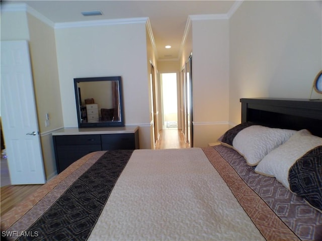 bedroom with wood-type flooring and ornamental molding