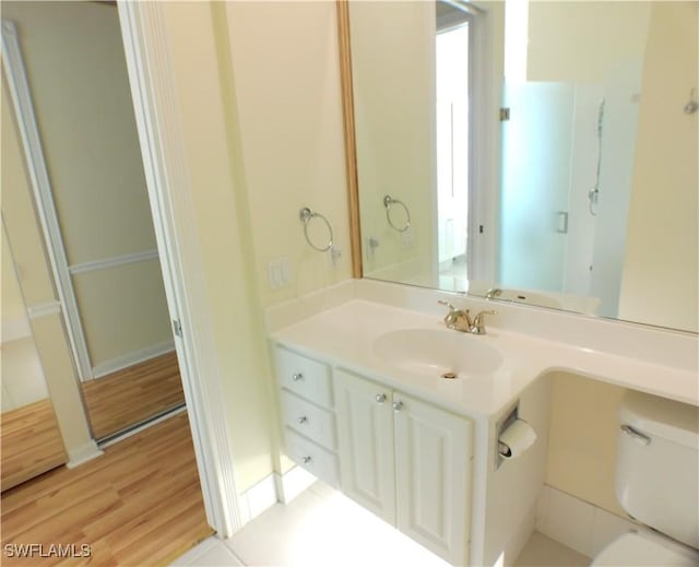 bathroom featuring vanity, toilet, and wood-type flooring