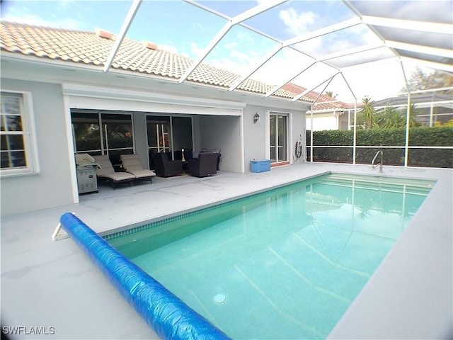 view of pool featuring outdoor lounge area, a patio, and glass enclosure