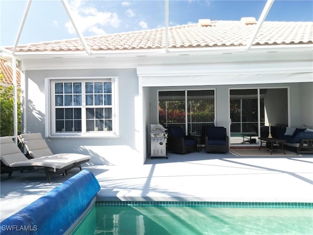 back of property featuring an outdoor living space, a covered pool, and a patio