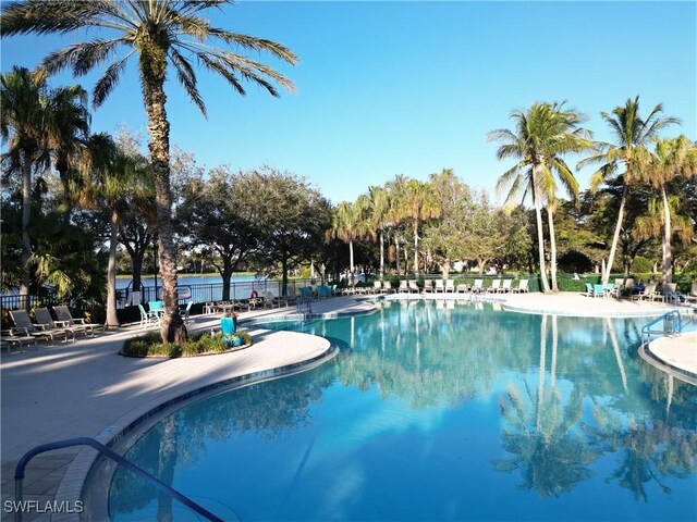 view of swimming pool with a patio and a water view