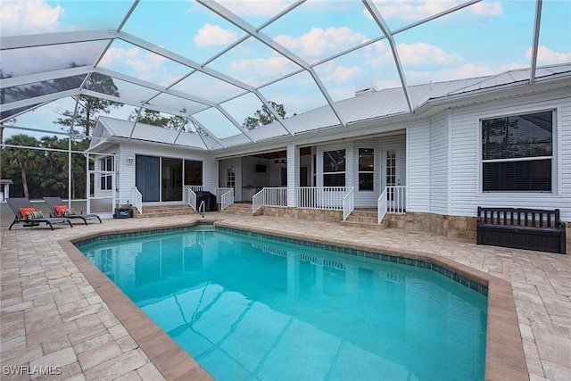 view of swimming pool with glass enclosure and a patio