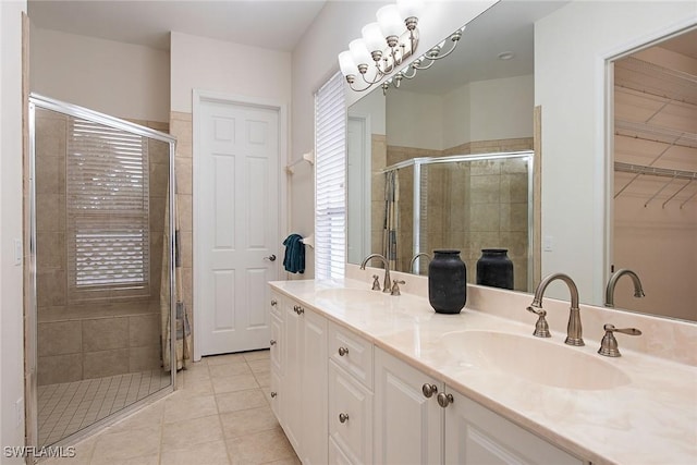 bathroom featuring a shower with shower door, tile patterned floors, a notable chandelier, and vanity