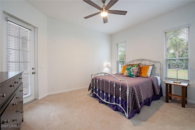 bedroom featuring ceiling fan, light colored carpet, and multiple windows