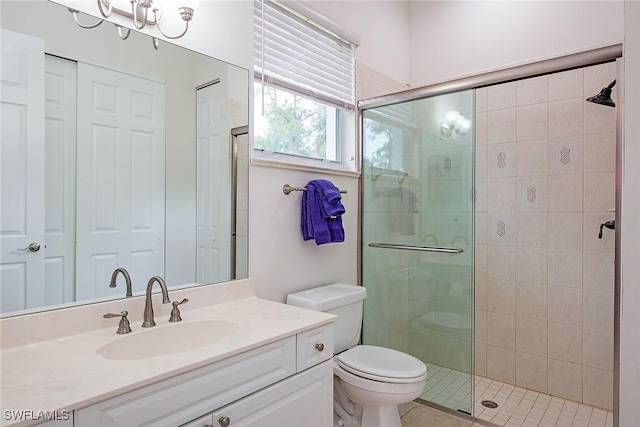 bathroom featuring toilet, a shower with door, and vanity