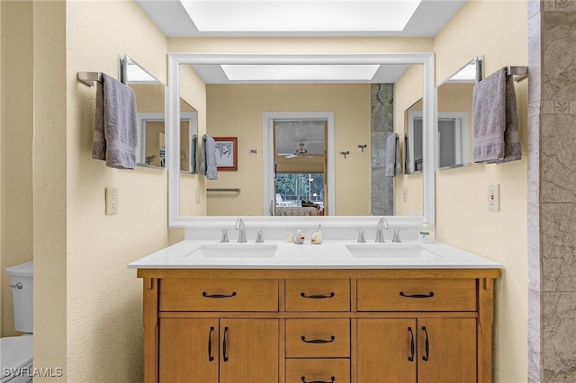 bathroom with plenty of natural light, toilet, and vanity