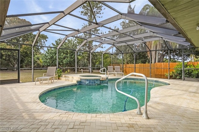 view of swimming pool featuring glass enclosure, an in ground hot tub, and a patio