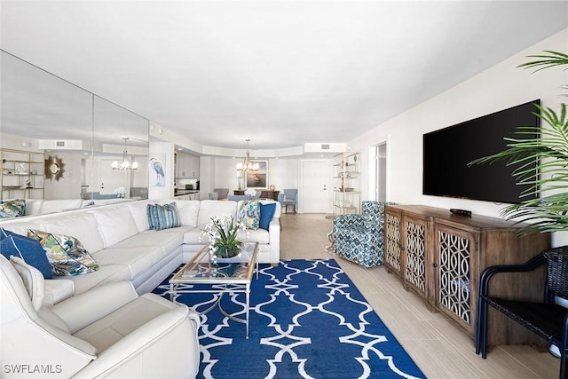 living room featuring light hardwood / wood-style floors and a chandelier