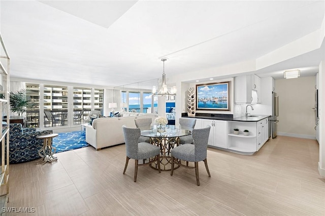 dining room featuring sink, a wall of windows, and an inviting chandelier