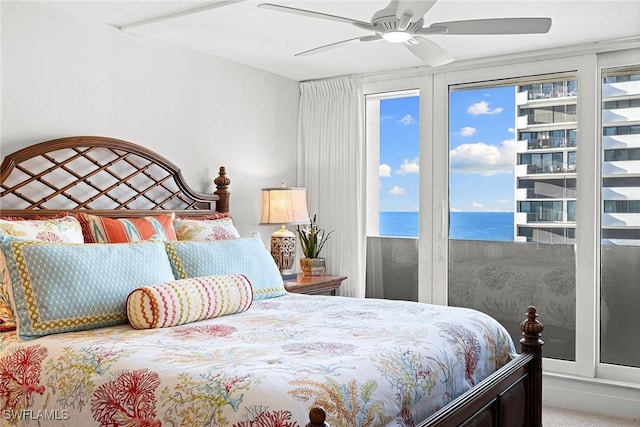 carpeted bedroom featuring multiple windows, a water view, and ceiling fan