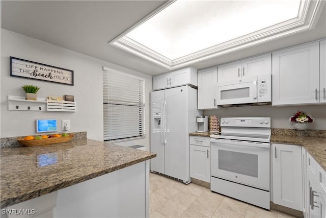 kitchen featuring white cabinetry, light tile patterned floors, white appliances, and dark stone counters