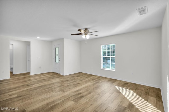 empty room with ceiling fan and light hardwood / wood-style flooring