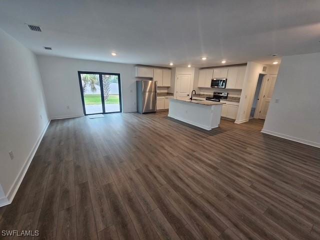 723 Brannen Ave, Lehigh Acres, FL 33974 - kitchen with stainless steel appliances, open floor plan, dark wood-style flooring, a kitchen island with sink, and recessed lighting