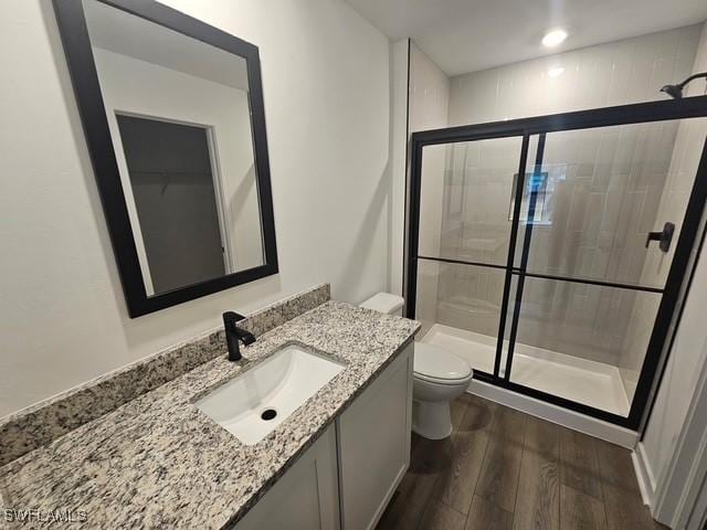 723 Brannen Ave, Lehigh Acres, FL 33974 - full bathroom featuring wood finished floors, a shower stall, toilet, and vanity