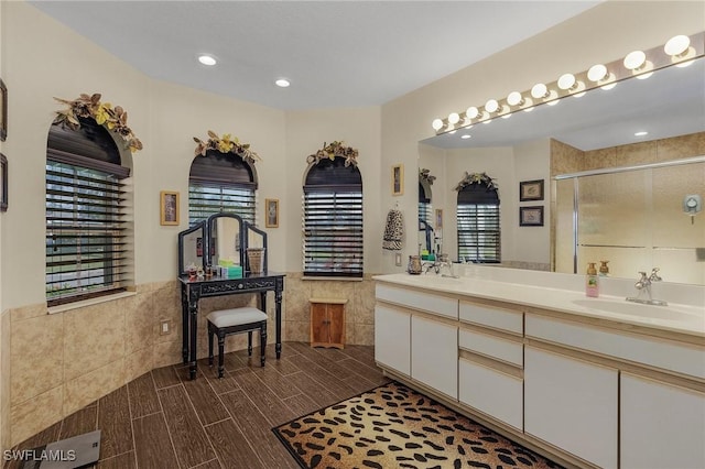 bathroom featuring vanity, tile walls, and an enclosed shower