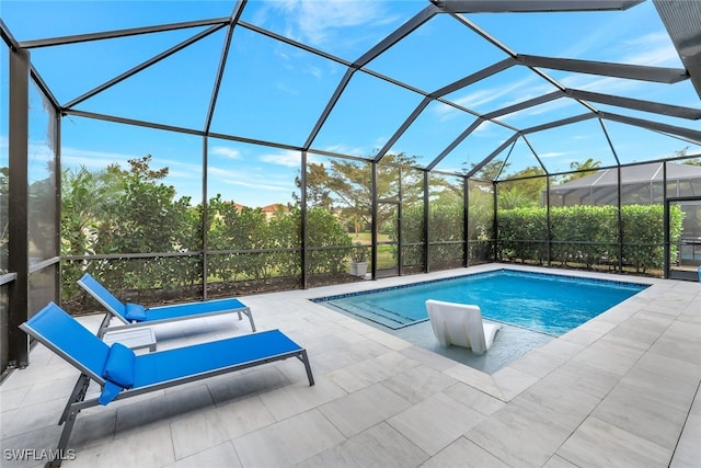 view of swimming pool with glass enclosure and a patio area