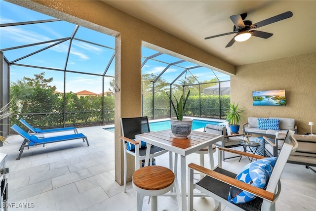 view of patio with outdoor lounge area, ceiling fan, and glass enclosure