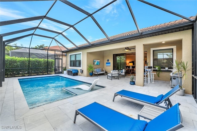 view of swimming pool with ceiling fan, a patio, an outdoor hangout area, and glass enclosure