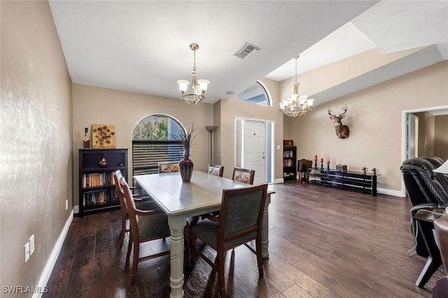 dining space featuring lofted ceiling, dark wood-type flooring, and a chandelier