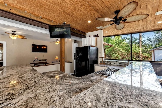 kitchen with black fridge, wooden ceiling, stone countertops, and white cabinets