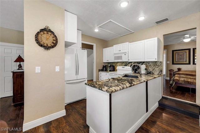 kitchen with white cabinetry, sink, dark stone counters, kitchen peninsula, and white appliances