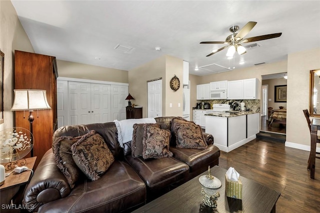 living room with ceiling fan and dark hardwood / wood-style flooring