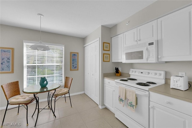 kitchen with hanging light fixtures, white appliances, white cabinets, and light tile patterned flooring