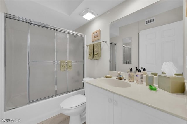 full bathroom featuring vanity, tile patterned floors, enclosed tub / shower combo, and toilet