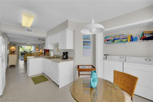 kitchen with white dishwasher, white cabinets, independent washer and dryer, and kitchen peninsula