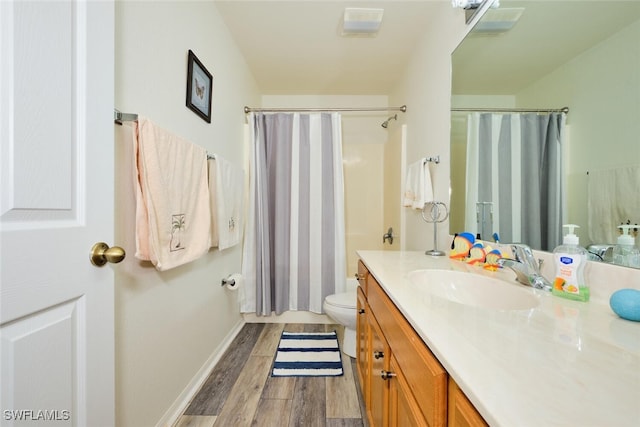 bathroom featuring a shower with curtain, wood-type flooring, vanity, and toilet