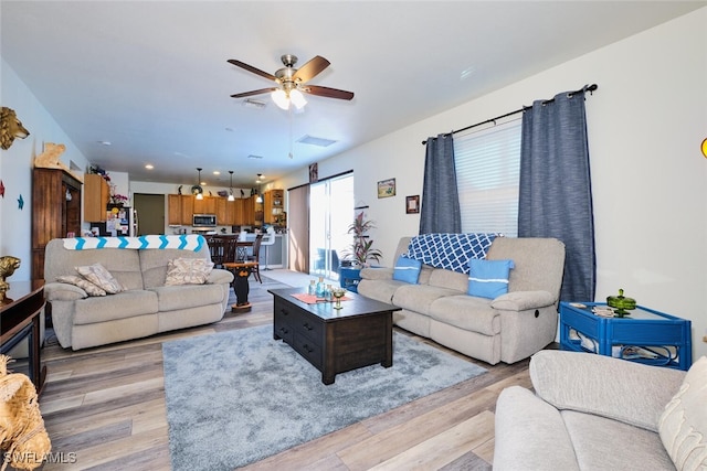 living room featuring ceiling fan and light hardwood / wood-style flooring