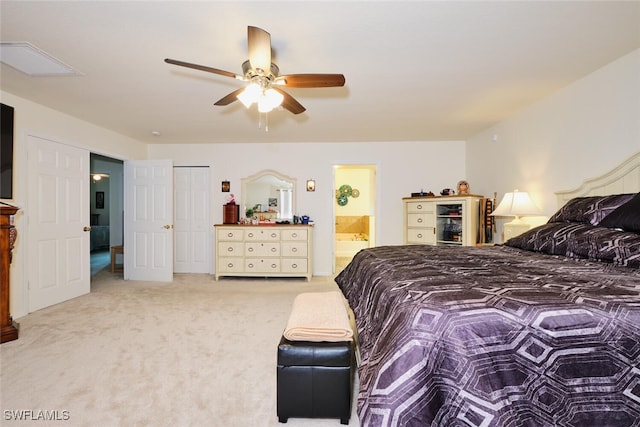 bedroom featuring ceiling fan, ensuite bath, and light carpet