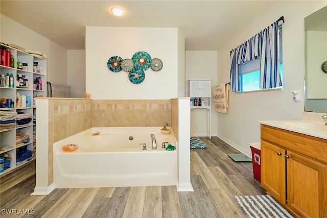 bathroom with vanity, hardwood / wood-style floors, and a bathing tub