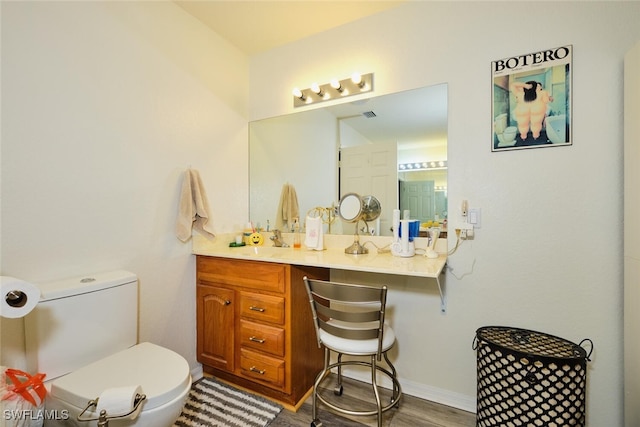 bathroom featuring vanity, hardwood / wood-style floors, and toilet