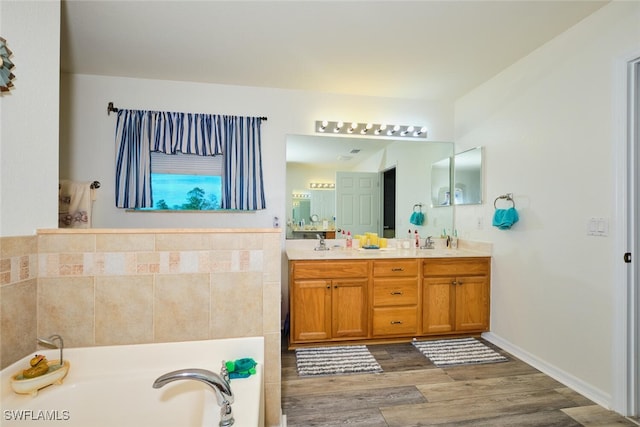 bathroom with vanity, a bath, and hardwood / wood-style floors