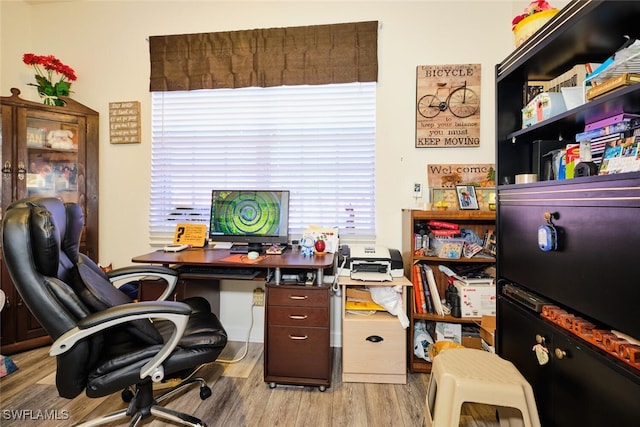 home office with light hardwood / wood-style flooring