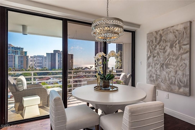 dining area featuring hardwood / wood-style floors, a notable chandelier, and floor to ceiling windows