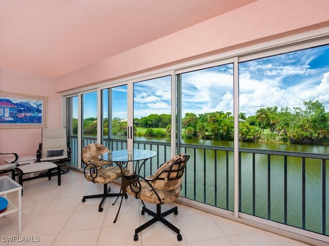 sunroom featuring a water view